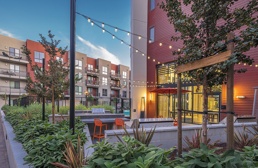 A modern apartment complex with a courtyard and string lights.